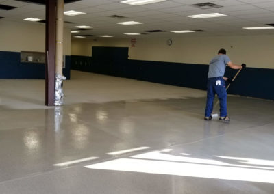 Contractor installing flooring in cafeteria