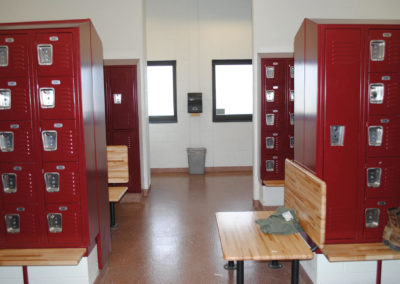 Red lockers with oak benches in school locker room