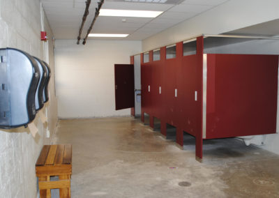 Multi stall bathroom with red toilet partitions