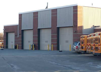 Exterior view of bus garage with large bay doors